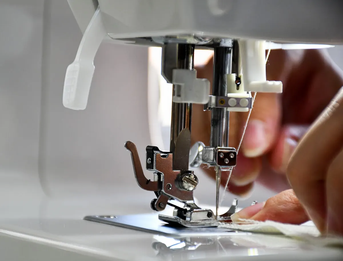 Upholsterer guiding fabric through a sewing machine Lee Verity Upholstery Wakefield